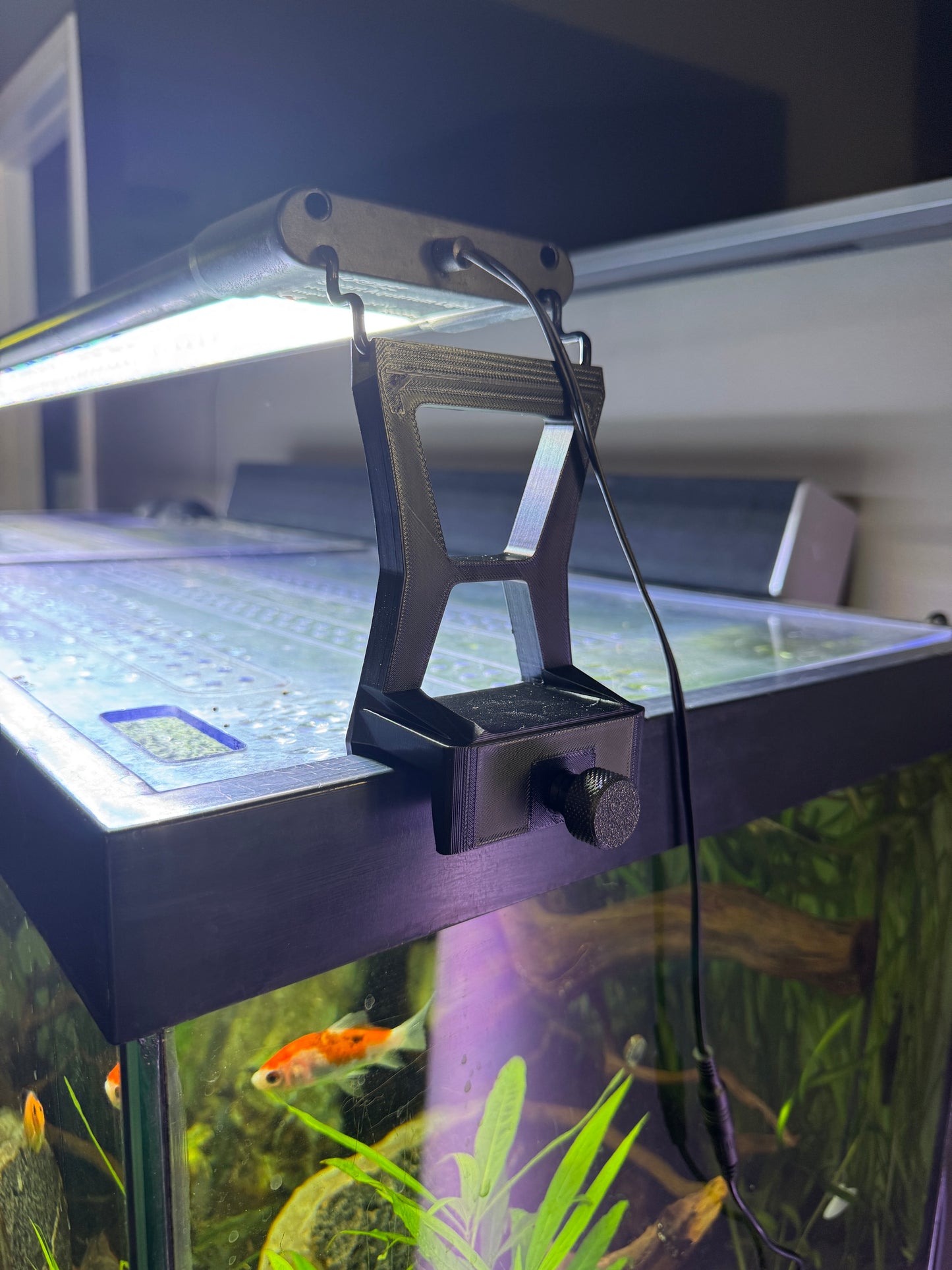 Fish tank with a power filter attached, showing fish swimming inside.