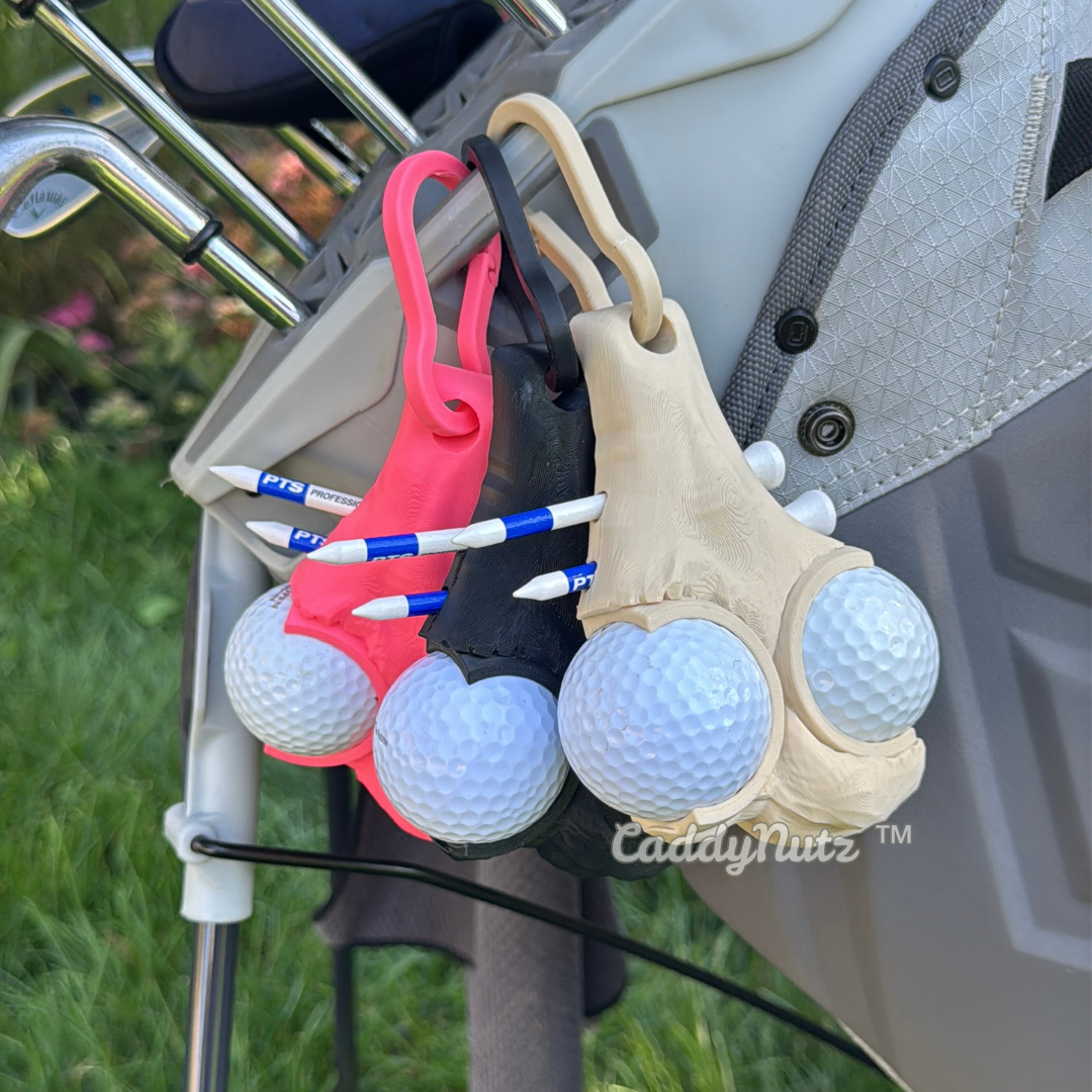Golf ball holder with golf balls attached to a golf bag on a golf course.