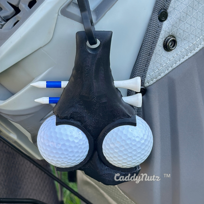 Golf ball holder with golf balls attached to a vehicle's door handle, featuring the brand 'CaddyNutz'.