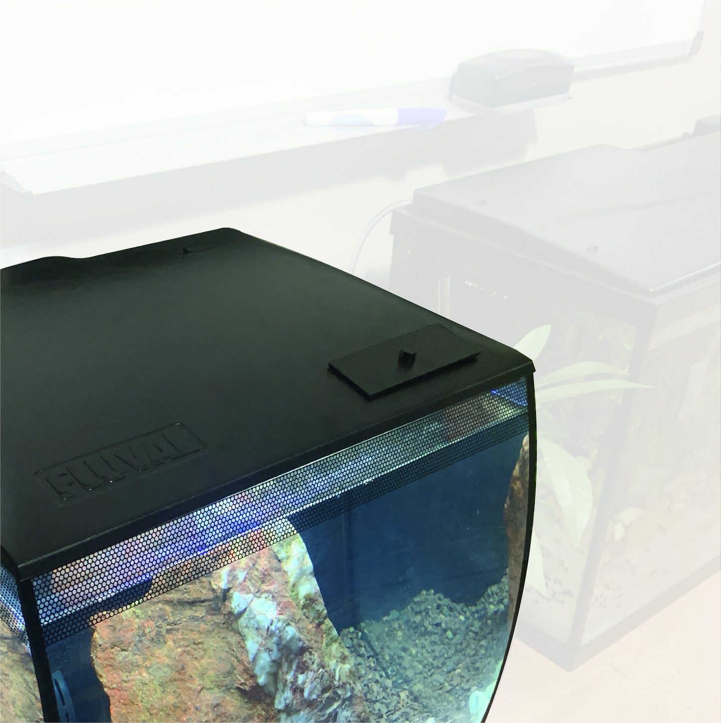 Fluval Flex 9G and 15G feed hole cover in black and white, designed to improve tank aesthetics while keeping the feeding area sealed from debris. Prevents small fish or shrimp from jumping into open areas and supports stable water parameters. Easy to install and remove.