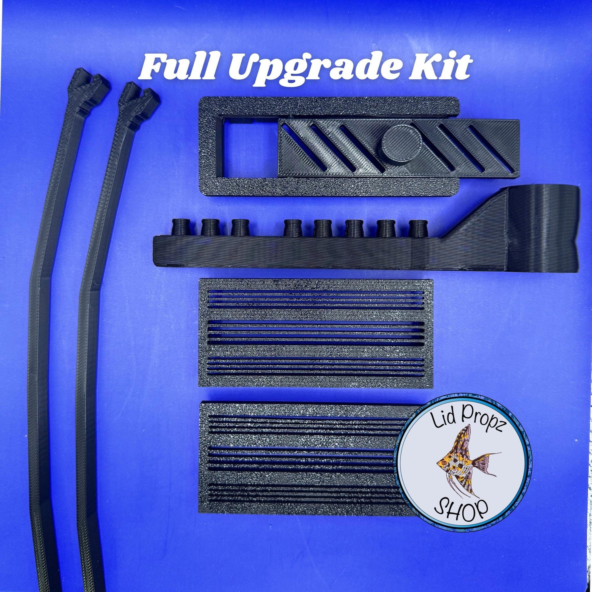 Fluval Flex upgrade kit components laid out: intake covers, feed hole cover, spray bar, and lid propz. Designed to improve safety and flow.
